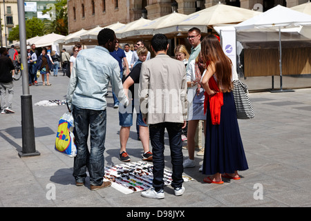 african immigrant street seller selling sunglasses to tourists barcelona catalonia spain Stock Photo