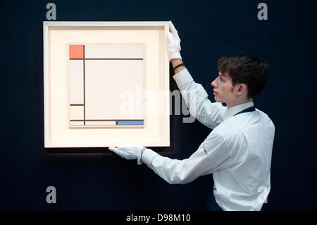 London,UK - 14 June 2013: A Sotheby's employee holds a work by Piet Mondrian entitled “Composition with red, Yellow amd Blue, 1927) (Est. £4.5-6.5 million) during the preview of this summer auction at Sotheby's. Credit:  Piero Cruciatti/Alamy Live News Stock Photo