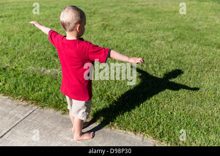 Little boy, age 4, looking at his late afternoon shadow. Stock Photo