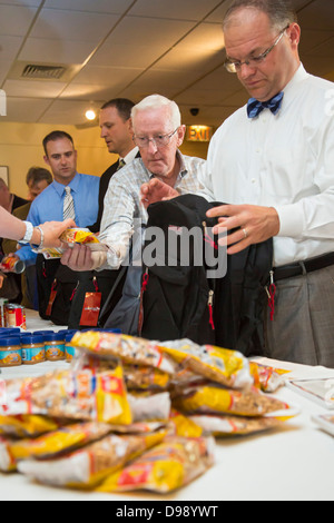 Business Executives Stuff Backpacks with Food for Hungry Children Stock Photo