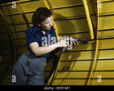 World War II 1939-1945: Woman working on a 'Vengeance' dive bomber, using a hand drill; Vultee-Nashville, Tennessee, USA, 1943. Labour Female War Effort Stock Photo