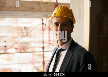portrait of male engineer smiling and looking at camera in construction site Stock Photo