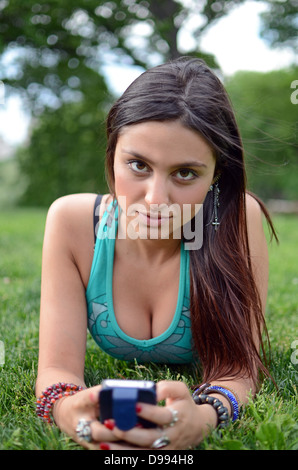Attractive young mixed race woman using mobile phone in Central Park, New York City Stock Photo