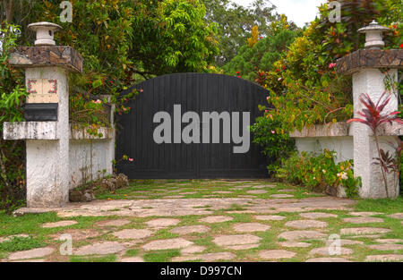 Black wooden front gate with concrete columns Stock Photo
