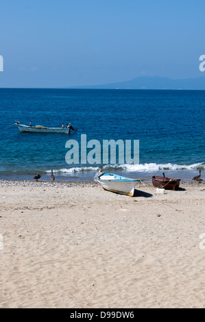 Fishing boats and nets drying in the sun with pelicans Stock Photo