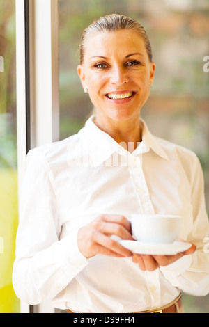 cheerful senior businesswoman with coffee in office Stock Photo
