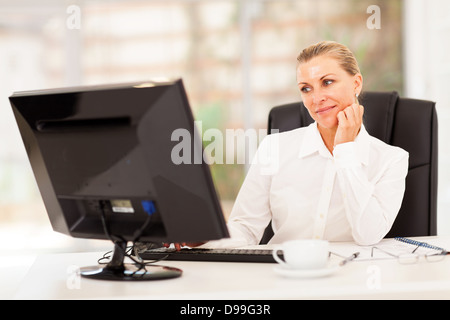 thoughtful senior businesswoman in front of computer Stock Photo
