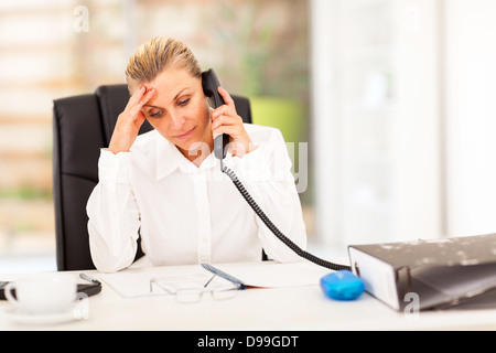 serious middle aged businesswoman talking on phone Stock Photo