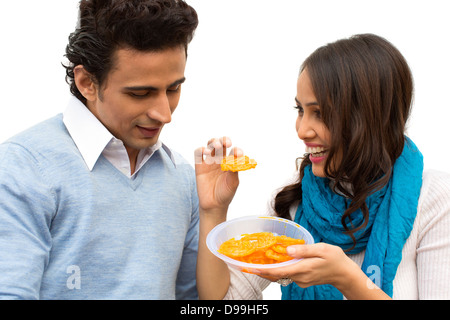 Woman feeding a jalebi to her boyfriend Stock Photo