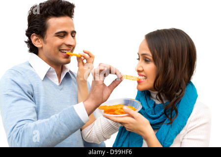 Smiling couple eating jalebis Stock Photo