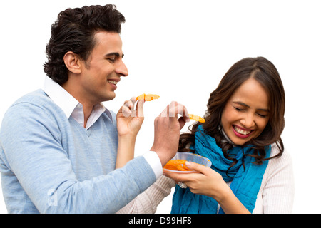 Smiling couple eating jalebis Stock Photo