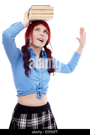Young schoolgirl trying to balance a pile of books on her head in ...
