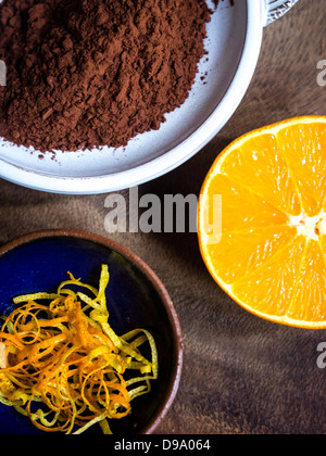 cocoa powder, lemon and orange zest strips, and a half orange showing delicious combination of flavours Stock Photo