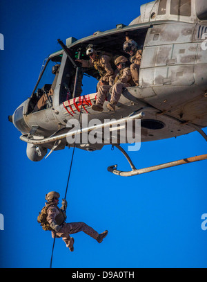 US Marine Corps Maritime Raid Force Marine members rappel from a UH-1N Huey during a helicopter rope suspension technique exercise at King Faisal Air Base June 11, 2013 in Jordan. Stock Photo