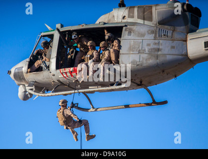 US Marine Corps Maritime Raid Force Marine members rappel from a UH-1N Huey during a helicopter rope suspension technique exercise at King Faisal Air Base June 11, 2013 in Jordan. Stock Photo