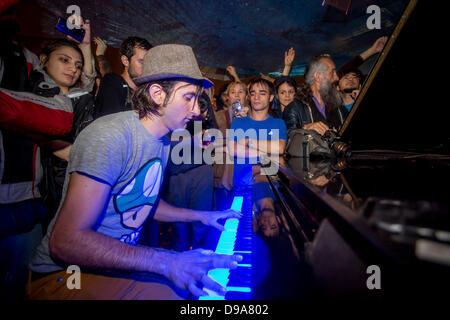 German pianist Davide Martello plays piano in pouring rain at the Taksim Square in Istanbul on 15 June 2013./dpa/Alamy Live News Stock Photo