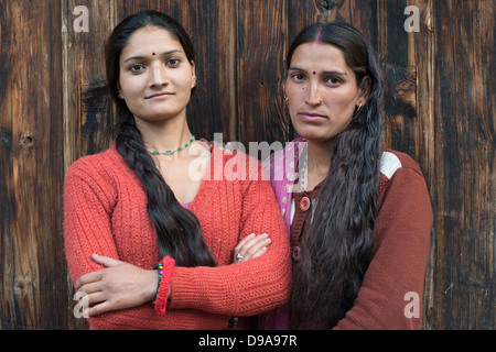 Two Gaddi tribeswomen pose for the camera at the Himalayan village of Kugti in Himachal Pradesh, India Stock Photo