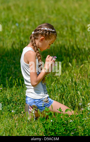 The girl collects flowers on a meadow Stock Photo