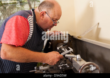 senior man operating lathe machine in workshop Stock Photo