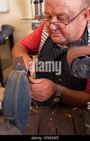 senior repairman using grinding machine Stock Photo