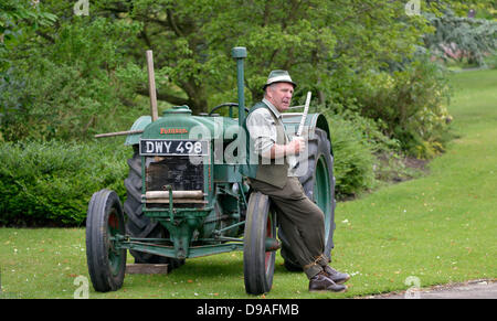 Harrogate, Yorkshire, UK. 16th June, 2013. A man stands by an old tractor at an event in Valley Gardens to raise money for The Magnesia Well Pump Room Project to create an exhibition on mineral springs. Credit:  John Fryer/Alamy Live News Stock Photo
