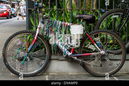 An old bike covered in beads parked at the French Quarter in New Orleans. Stock Photo