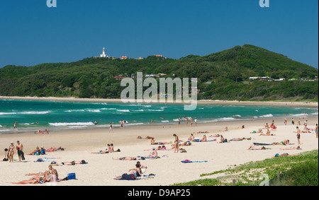 busy beach scene in Byron Bay with lighthouse in the background Stock Photo