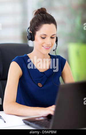 beautiful young online support operator working on laptop Stock Photo