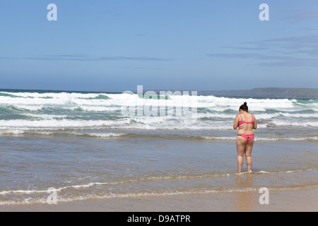 Woman in a pink polka dot bikini on Newquay beach Cornwall Stock Photo