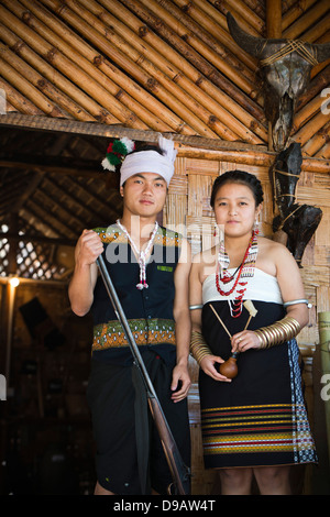 Naga tribal couple standing in their hut, Hornbill Festival, Kohima, Nagaland, India Stock Photo