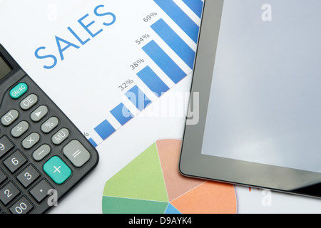 An ipad and a calculator placed on paper financial reports Stock Photo