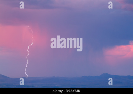 Thunderstorm with lightning and heavy rainclouds at sunset Stock Photo