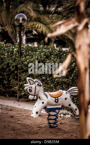 Spring rocking horse in children's outdoor play area at holiday resort. Stock Photo