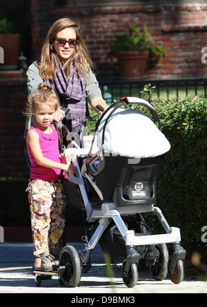 Honor Marie Warren hitches a ride on the side of the baby stroller as Jessica Alba pushes Haven Warren during a family day out at the park Beverly Hills, California - 28.01.12 Stock Photo