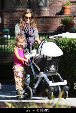 Honor Marie Warren hitches a ride on the side of the baby stroller as Jessica Alba pushes Haven Warren during a family day out at the park Beverly Hills, California - 28.01.12 Stock Photo