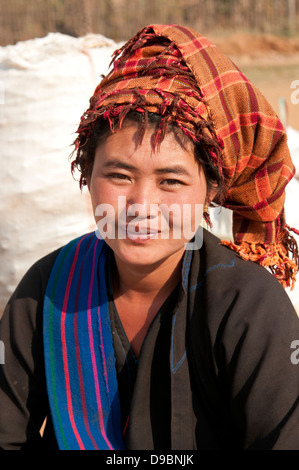 Young Pa-O woman wearing orange checked traditional headdress smiling at the camera in a market Myanmar (Burma) Stock Photo