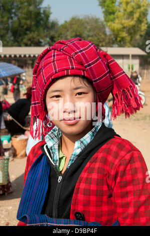 Pretty Pa-O girl wearing a red checked headdress looking at the camera in a market Myanmar (Burma) Stock Photo