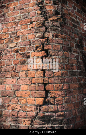 Brick building structure with a large crack running down the center. Stock Photo