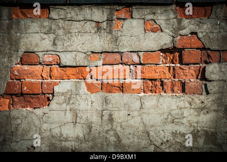 An old eroded terracotta red brick wall background with broken plaster. Stock Photo