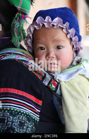 Sapa, Vietnam circa Feb 2013 A little baby boy from the Black Hmong indigenous tribe of SaPa, Vietnam on his mother's back Stock Photo
