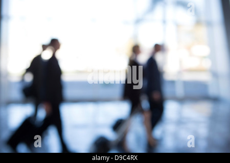 Businesspeople walking through airport, defocused Stock Photo