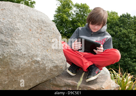 young male boy using ipad mini tablet computer Stock Photo