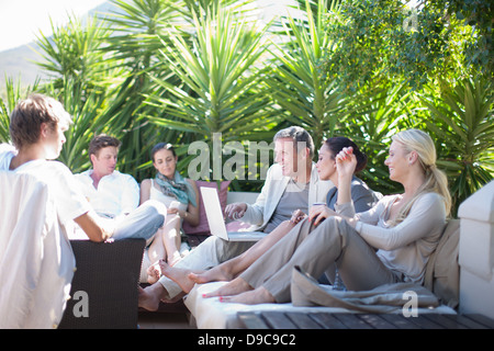 Casual business people on patio using laptop Stock Photo