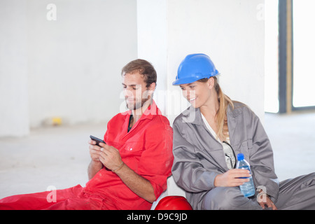 Construction workers sitting on floor taking a break Stock Photo