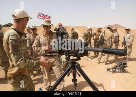 A US Marine with the 26th Marine Expeditionary Unit conducts weapon familiarization on a Grenade Machine Gun with a Royal Marine from the 42 Commando Royal Marines June 9, 2013 in Al Humaymah, Jordan. More than 5,000 multinational soldiers are participating in the exercises to counter the civil war in neighboring Syria. Stock Photo