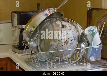 Clean dished stacking and drying in a kitchen dish drain Stock Photo