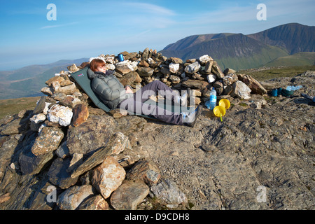 A hiker wild camping on the summit of Robinson in the Lake District Stock Photo