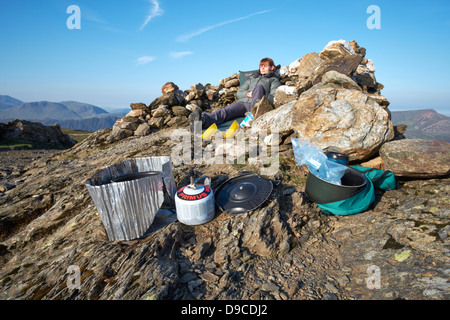 A hiker camping on the summit of a Robinson in the Lake District. Stock Photo