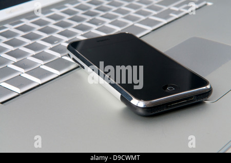 Cell phone on computer laptop Stock Photo