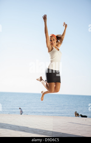 Young woman jumping mid air Stock Photo
